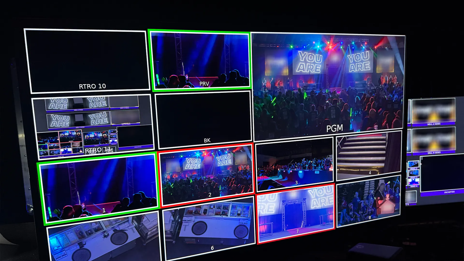 Multi-camera video monitor displaying stage and audience views during a live corporate competition