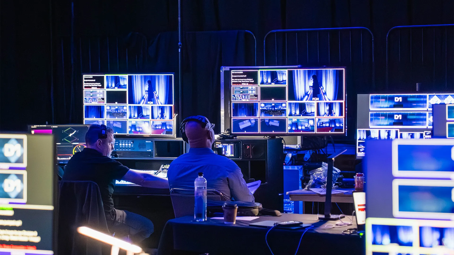 Technical production team monitoring multiple camera feeds during a live corporate event