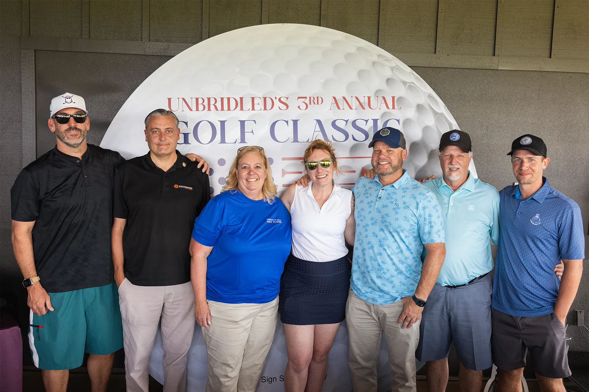 Volunteers of America Colorado Unbridled Classic golf tournament group photo with event signage